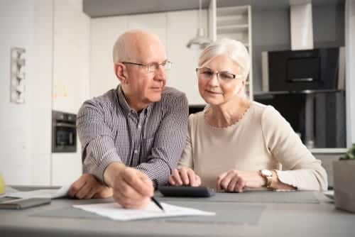 Senior,Couple,Discussing,Investment,,Checking,Their,Bills,At,Home Senior couple discussing what to look for in a final expense policy.